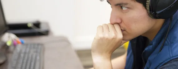 Person staring at laptop wearing headphones