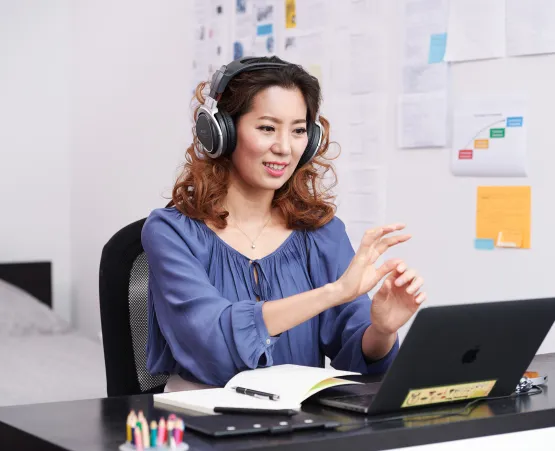 woman looking at laptop with headphones on